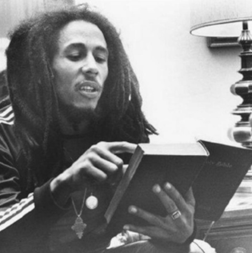 Bob Marley, pictured reading, was a devout Christian, according to his personal photographer. Credit: supplied.