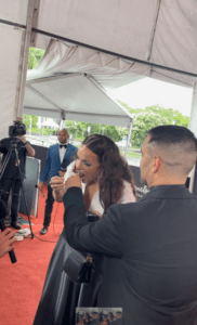 Abbie Chatfield tucks into a Tim Tam on the AACTAs red carpet. Credit: BACKCOVERNEWS.COM