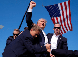 Former President Donald Trump is surrounded by U.S. Secret Service agents after apparent shots were fired at his campaign rally, July 13, 2024, in Butler, Pa. Credit: AP