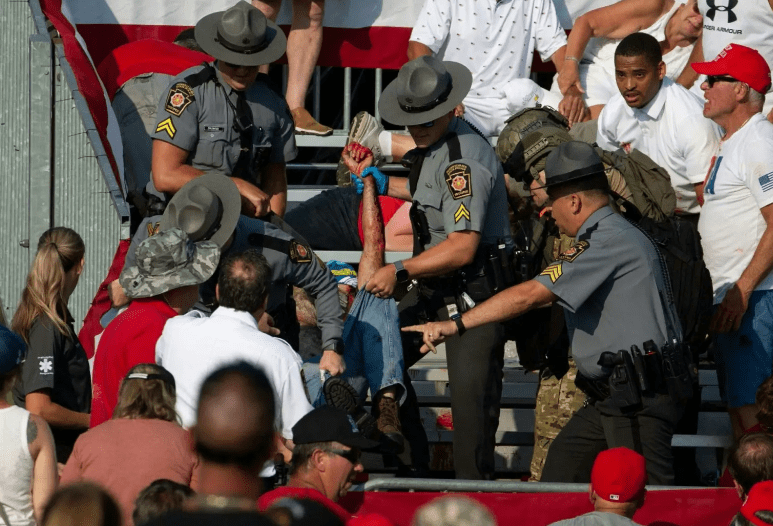 A person, believed to be a bystander, is pictured being removed from the stands. Credit: AFP via Getty Images